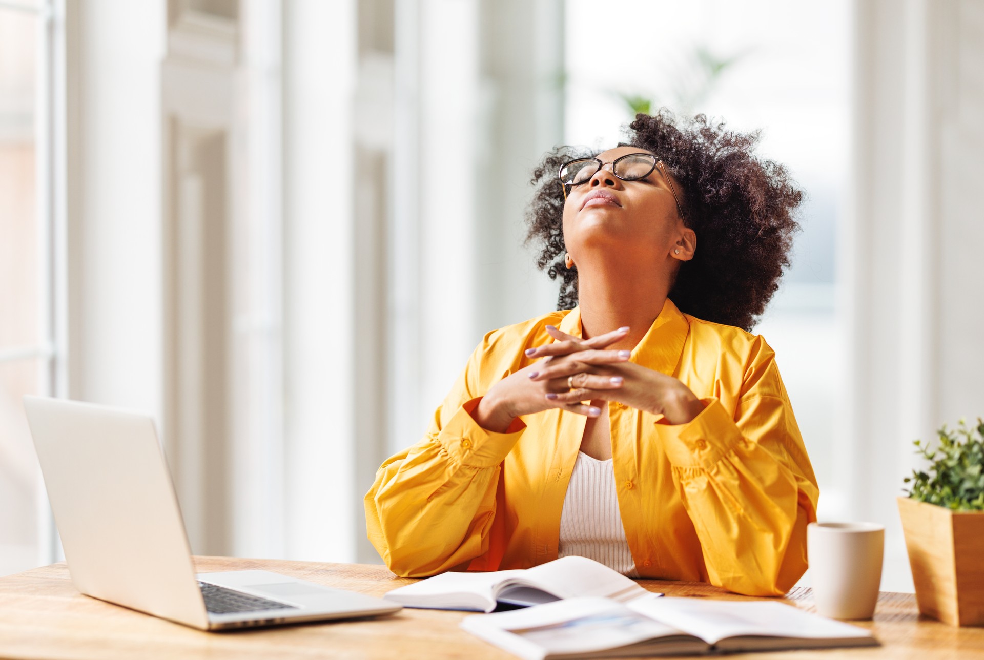 Frustrated young african american  woman suffering from headache   feeling stressed with work at laptop