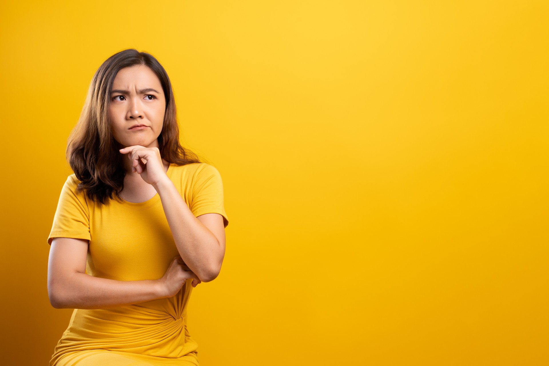 Woman feel confused isolated over yellow background